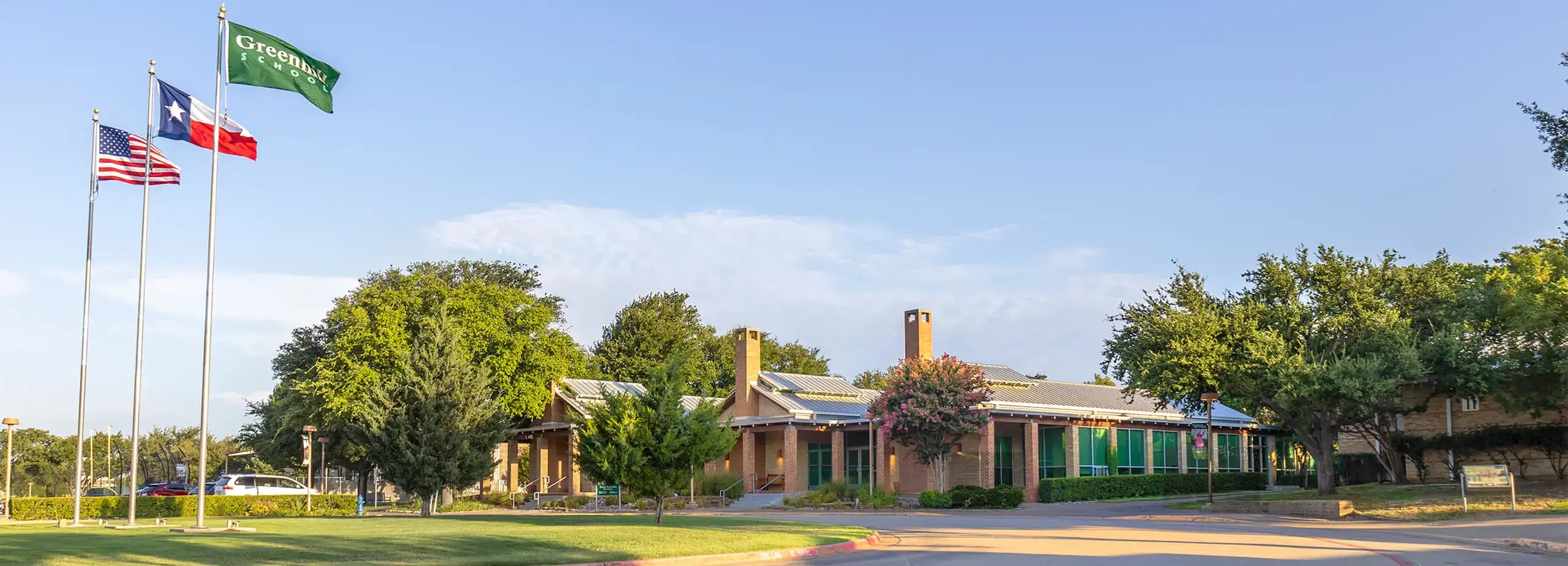 Three Chimneys Administration Building and circle drive with flags. 